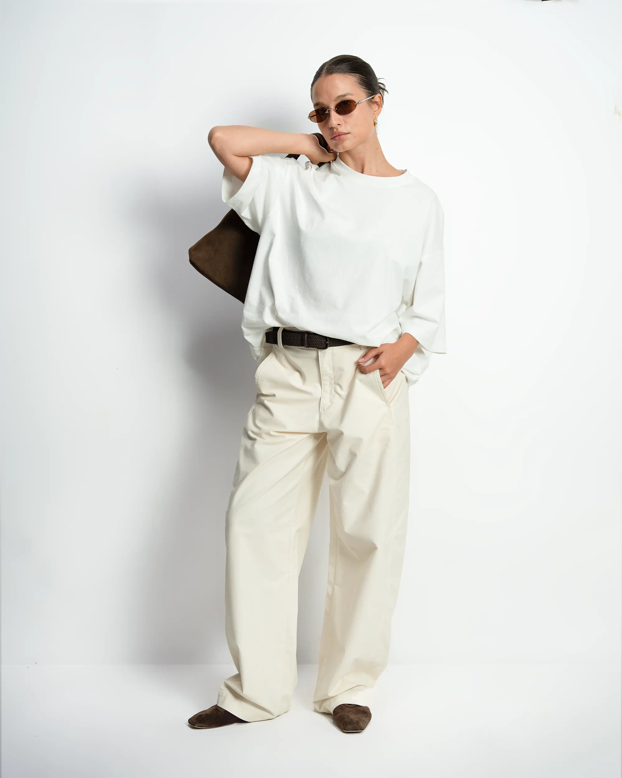 Female model in an oversized white tee and cream trousers