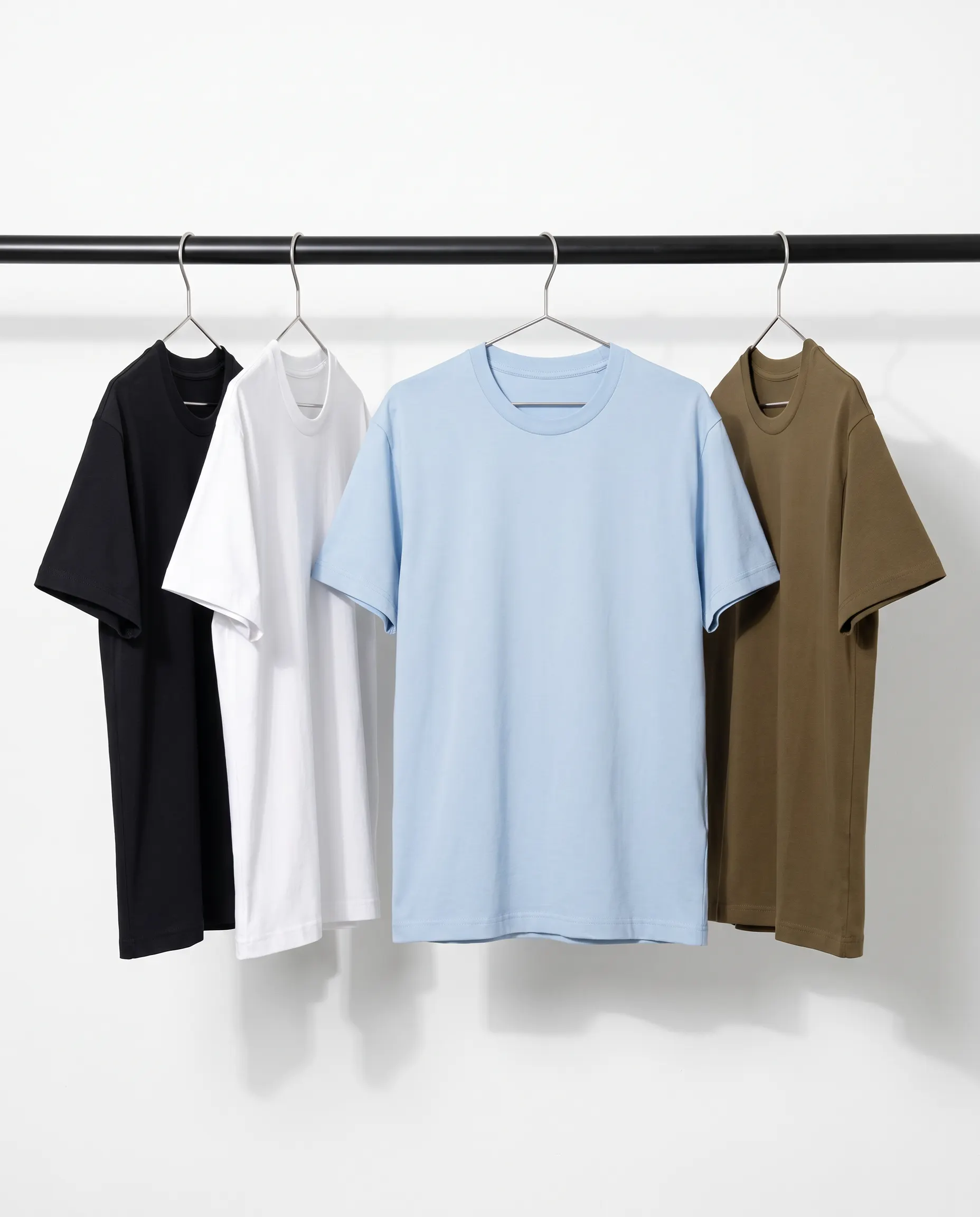 Black, white, blue and olive T-shirts on hangers