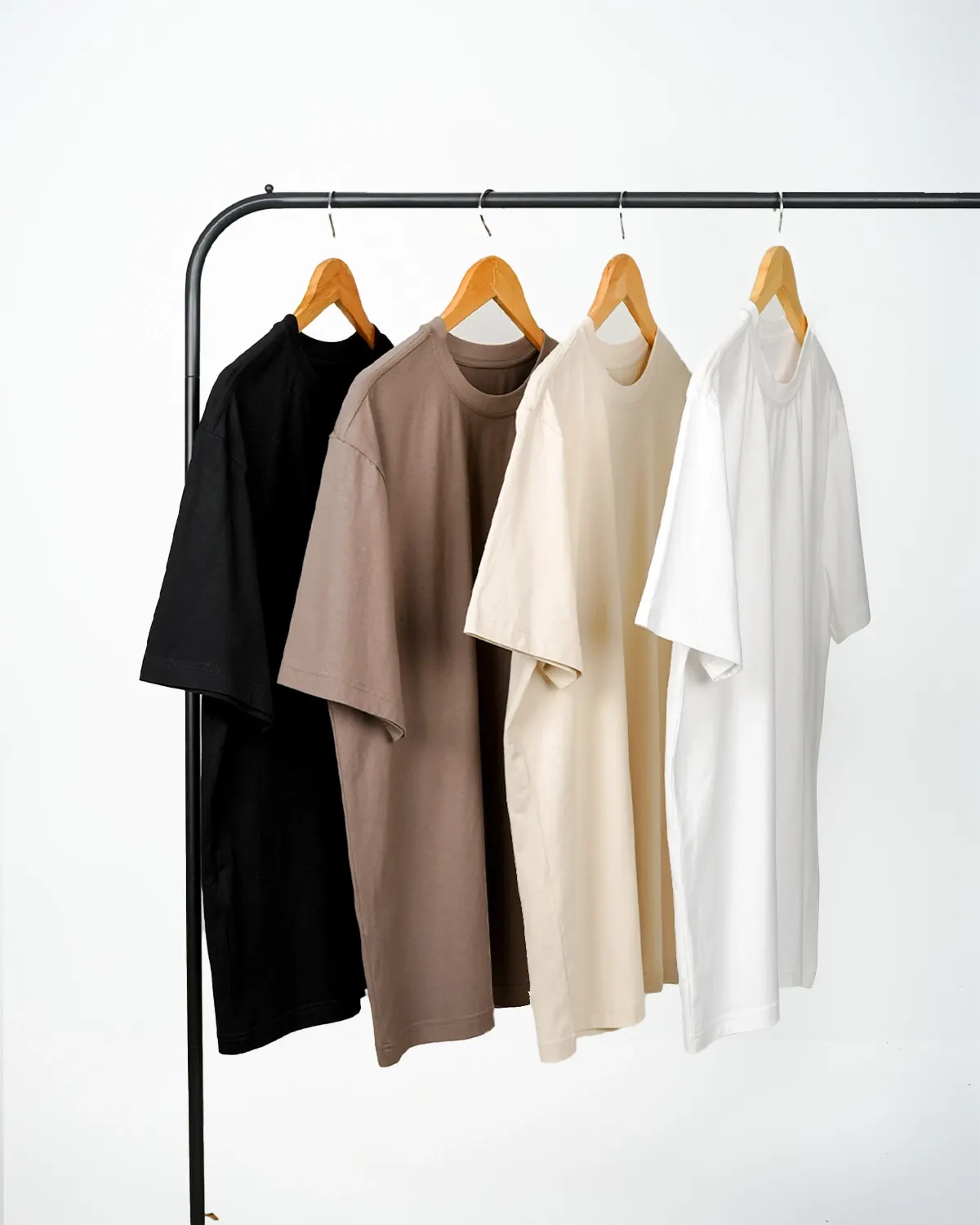 Black and taupe T-shirts hanging on a clothes rail