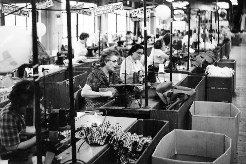 Kheel Center Women sewing at a garment factory with election signs for Johnson Humphrey and others overhead 1964